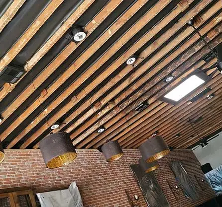Exposed Wooden Beams in Commercial Space with Brick Walls and Lighting Fixtures